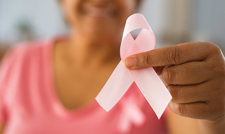 Breast Cancer Awareness Month Ribbon Woman holding up a pink ribbon signifying breast cancer awareness month